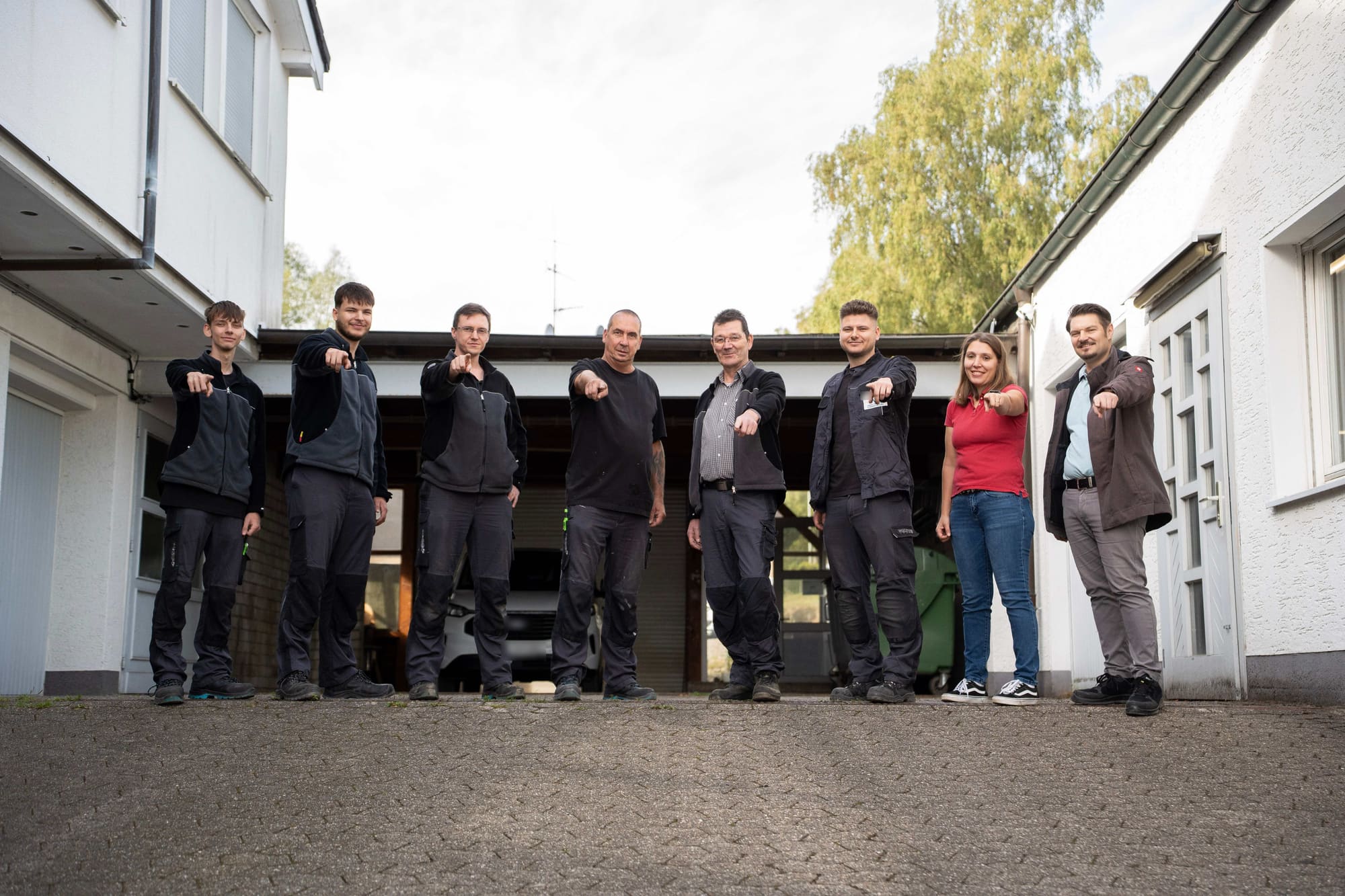 Das GvD-Team steht im Hof und zeigt in die Kamera