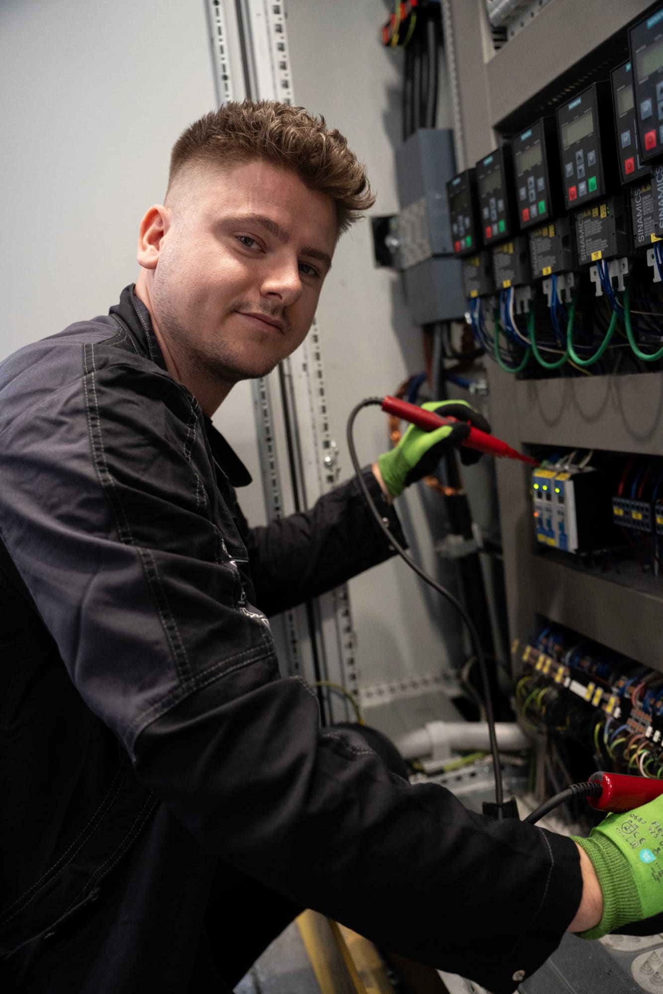 GvD-Elektroniker misst mit Spannungsprüfer an einem Schaltschrank mit Siemens-Frequenzumrichtern
